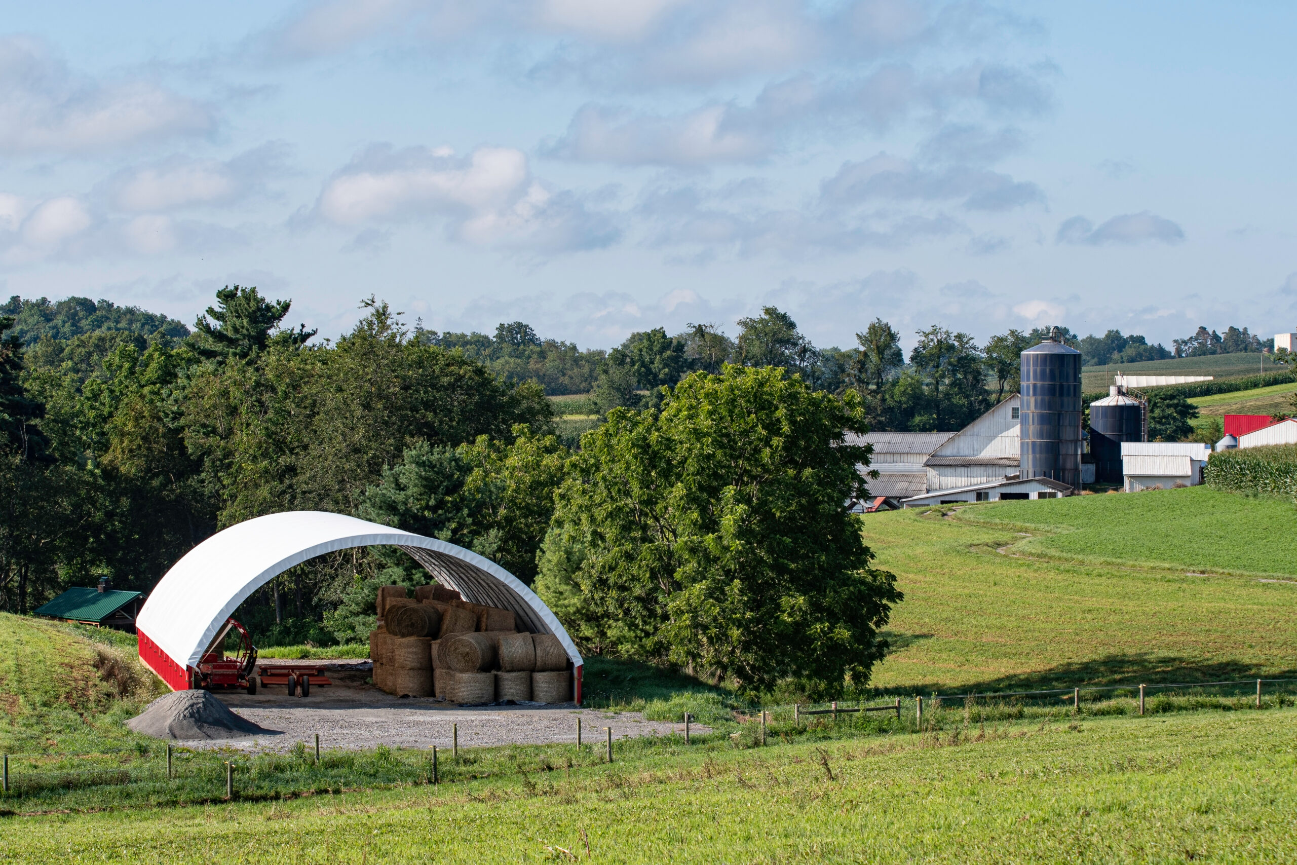 Traditional,Farm,Buildings,In,The,Background,With,A,Modern,Hoop Traditional,Farm,Buildings,In,The,Background,With,A,Modern,Hoop