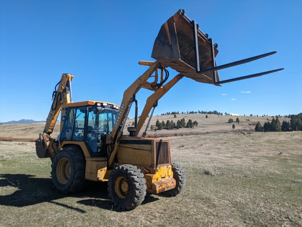 Bucket Fork Kits for Loaders, Skid Steers, Tractors and Backhoes 1 bucket fork kit on a bucket lifted up in the air